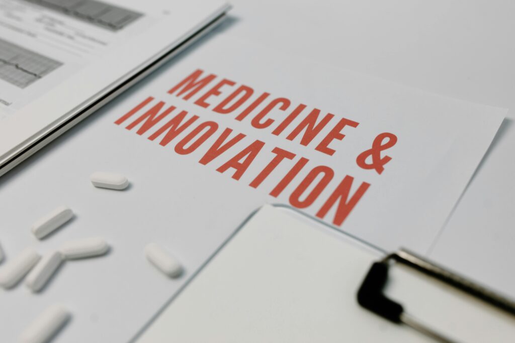 Close-up of 'Medicine & Innovation' paper with pills and documents on a desk.